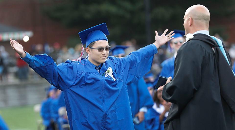 Lawrence Ka-Wing Ching receives his diploma with open arms from Principal Lawrence Taglieri during Quincy High School graduation at Veterans Stadium on Tuesday, June 7, 2022.