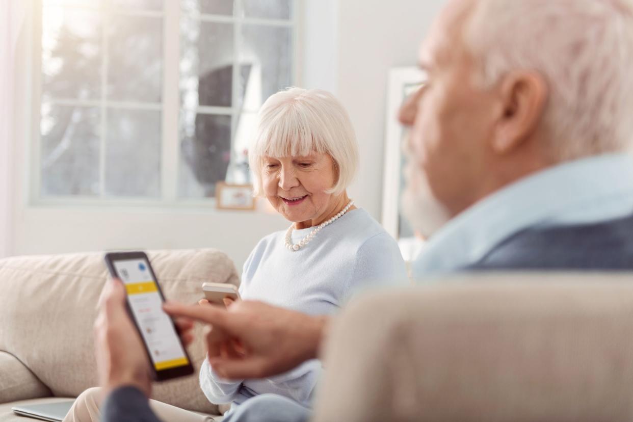 elderly couple using mobile applications on their gadgets