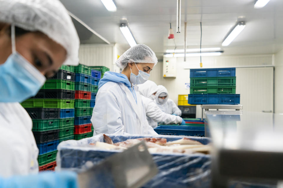 people in a kitchen wearing masks and hair coverings