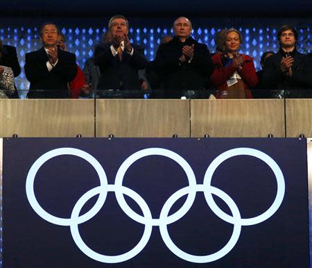 Secretary-General of the United Nations Ban Ki-moon (L), International Olympic Committee President Thomas Bach (2nd L) and President of Russia Vladimir Putin applaud during the opening ceremony of the 2014 Sochi Winter Olympics, February 7, 2014. REUTERS/Brian Snyder