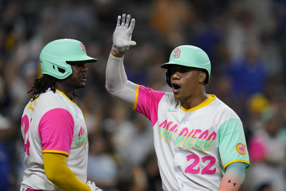 San Diego Padres' Juan Soto (22) celebrates with Josh Bell after scoring from first on a fielding error by Los Angeles Dodgers right fielder Mookie Betts during the fifth inning of a baseball game Friday, Sept. 9, 2022, in San Diego. (AP Photo/Gregory Bull)