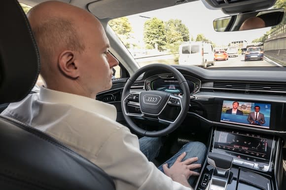 A view of the dashboard of an Audi in a highway traffic jam.