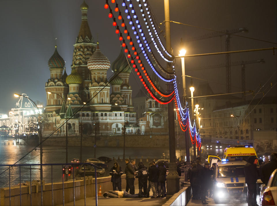 FILE - Russian police surround the body of Boris Nemtsov, a charismatic former deputy prime minister who was shot to death on a bridge just off Red Square, with St. Basil Cathidral in the background, in Moscow, Russia on Saturday, Feb. 28, 2015. His death brought thousands into the streets of Moscow, where they were allowed to protest unimpeded by police – unlike after the scene after the Feb. 16, 2024, death in prison of Alexei Navalny, a political foe of President Vladimir Putin. Mourners trying to lay flowers at makeshift memorials to Navalny were quickly arrested. (AP Photo/Pavel Golovkin, File)