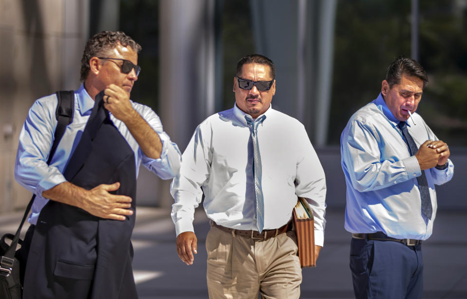 Lawyer Mark Fleming, left, walks with defendant Albert Lopez past defendant Bradley Campos outside the Lloyd George U.S. Courthouse Thursday, Feb. 6, 2020, following opening statements in a federal racketeering trial for eight Vagos Motorcycle Club members on Aug. 12, 2019, in Las Vegas. (L.E. Baskow/Las Vegas Review-Journal via AP)