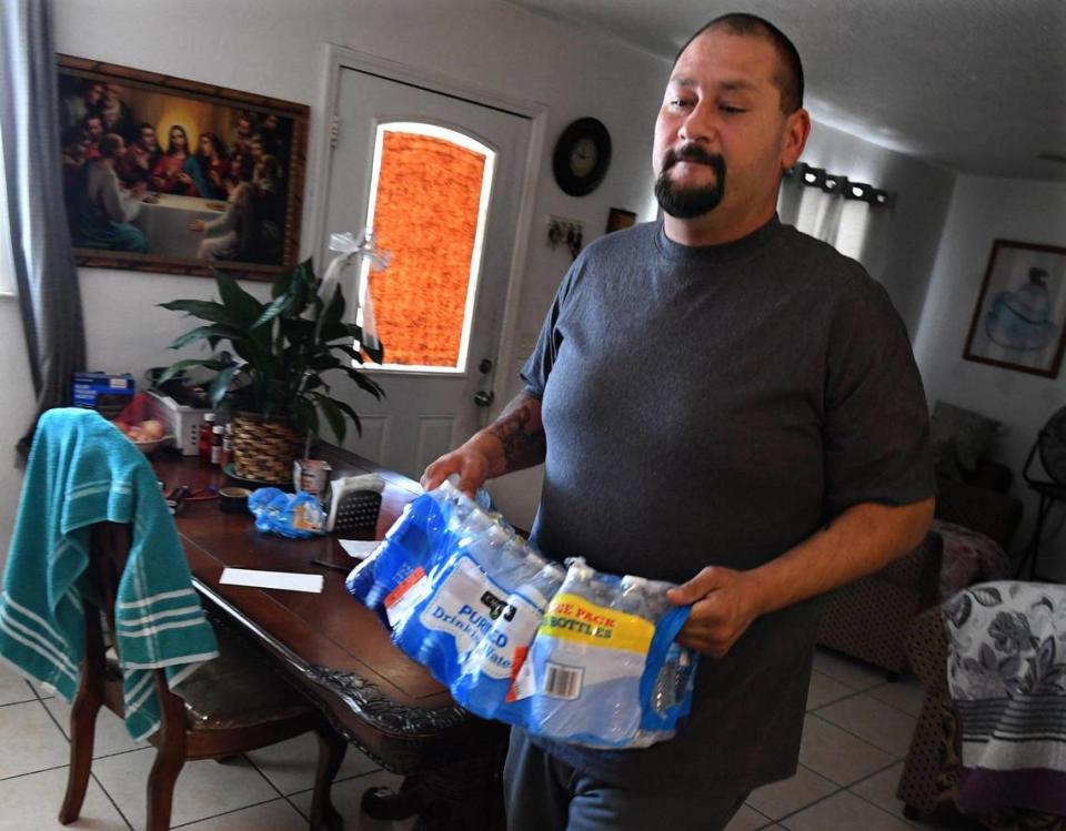 Earlimart native Alejandro Valenzuela hauls into his kitchen a case of bottled water, which he still uses despite the recently-lifted boil-order by the city for household use of water from the town’s well.