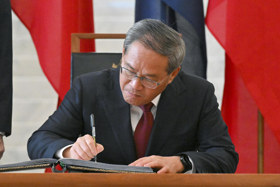 Chinese Premier Li Qiang signs the visitor book at Parliament House in Canberra, Australia, Monday, June 17, 2024. Li and Australian Prime Minister Anthony Albanese and senior ministers of both administrations met at Parliament House on Monday to discuss thorny issues, including lingering trade barriers, conflict between their militaries in international waters and China's desire to invest in critical minerals. (Mick Tsikas/Pool Photo via AP)