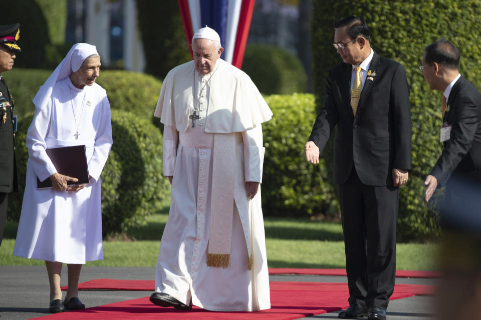 Pope Francis, center, walks with his cousin Ana Rosa Sivori, left, and Thailand's Prime Minister Prayuth Chan-ocha, second from right, during a welcome ceremony at the government house in Bangkok, Thailand, Thursday, Nov. 21, 2019. Pope Francis is on a four-day visit to Thailand. (AP Photo/Wason Wanichakorn)