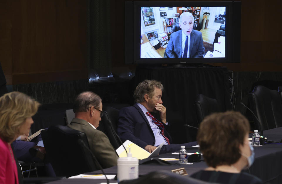 FILE - Senators listen as Dr. Anthony Fauci, director of the National Institute of Allergy and Infectious Diseases, speaks remotely during a virtual Senate Committee for Health, Education, Labor, and Pensions hearing, May 12, 2020 on Capitol Hill in Washington. Seated from left are Sen. Lisa Murkowski, R-Alaska, Sen. Mike Braun, R-Ind., center, and Sen. Rand Paul, R-Ky. Fauci steps down from a five-decade career in public service at the end of the month, one shaped by the HIV pandemic early on and the COVID-19 pandemic at the end. (Win McNamee/Pool via AP, File)