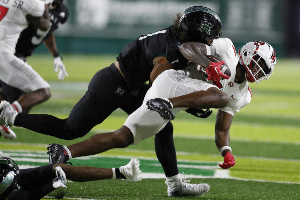 Hawaii linebacker Penei Pavihi (1) pulls down Western Kentucky wide receiver Malachi Corley (11) during the second half of an NCAA college football game, Saturday, Sept. 3, 2022, in Honolulu. (AP Photo/Marco Garcia)