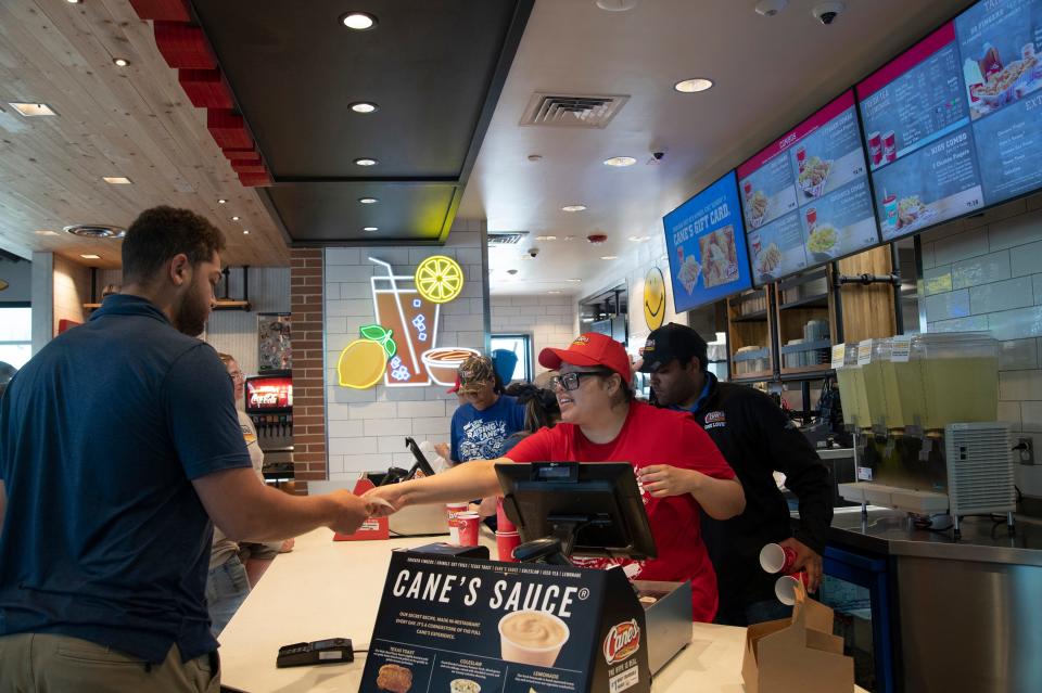 Emmely Pacheco, right, of Marlborough, waits on a customer during the grand opening of Raising Cane's Chicken Fingers on Boston Post Road West in Marlborough, May 17, 2023.