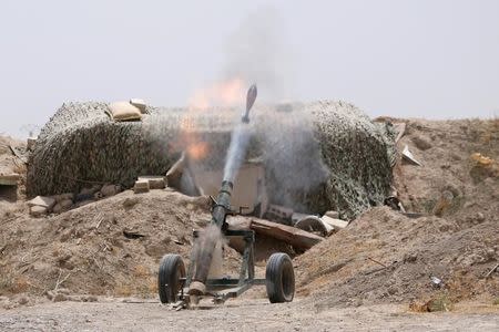 Fighters of the Syria Democratic Forces fire a mortar shell towards positions held by Islamic State fighters in northern province of Raqqa, Syria May 27, 2016. REUTERS/Rodi Said