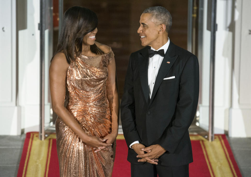 Barack y Michelle Obama (trajeada con un elegante vestido de Versace) sonríen en la última cena de estado. (Foto: Getty)