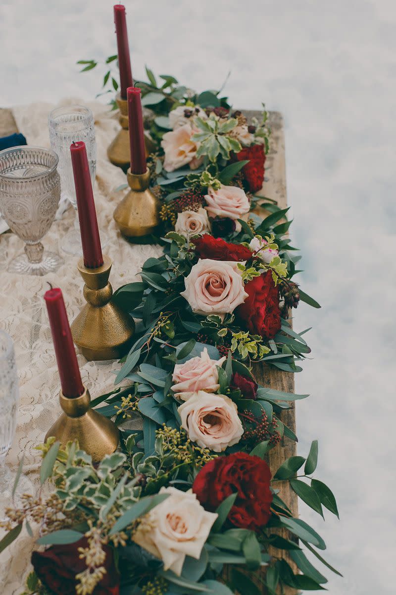 <p>A garland centerpiece adds a wisp of whimsy and romance to practically any table. This garland incorporates pastel pink roses and deep red flowers—which echo the jewel tone of the candles—for a holiday centerpiece that is equal parts traditional and contemporary. </p><p><em>Via <a href="http://junebugweddings.com/wedding-blog/passionate-winter-elopement-inspiration-emerald-lake/" rel="nofollow noopener" target="_blank" data-ylk="slk:Junebug Weddings;elm:context_link;itc:0;sec:content-canvas" class="link ">Junebug Weddings</a></em></p>