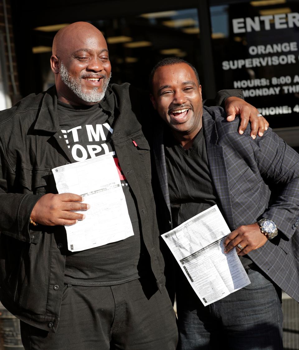 FILE- In this Jan. 8, 2019, file photo, Desmond Meade, president of the Florida Rights Restoration Coalition, left, and David Ayala, husband of State Attorney Aramis Ayala, celebrate after registering to vote at the Supervisor of Elections in Orlando, Fla. Both had been convicted of felonies. The effort to register Floridaâ€™s newly eligible felons to vote is being stymied by the coronavirus pandemic and a disputed requirement that felons pay a series of costs. (AP Photo/John Raoux, File)