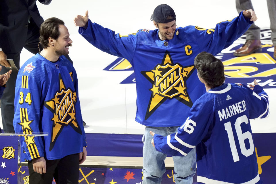 Team Matthews' Auston Matthews, left, and Justin Bieber, center, pick Mitch Marner (16) during the NHL All-Star hockey week draft in Toronto on Thursday, Feb. 1, 2024. (Nathan Denette/The Canadian Press via AP)
