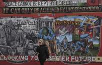 A pedestrian walks past a political mural on a street near a polling station on polling day for the Northern Ireland Assembly elections, in East Belfast in Northern Ireland, March 2, 2017. REUTERS/Toby Melville