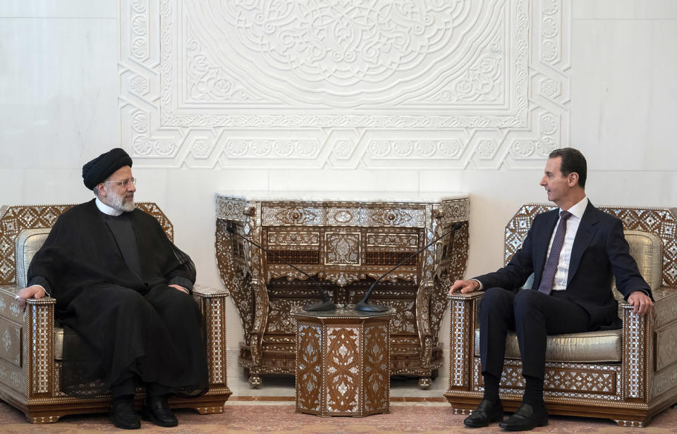 In this photo released by the official Facebook page of the Syrian Presidency, Syrian President Bashar Assad, right, meets with Iranian President Ebrahim Raisi at the presidential palace in Damascus, Syria, Wednesday, May 3, 2023. (Syrian Presidency via Facebook via AP)