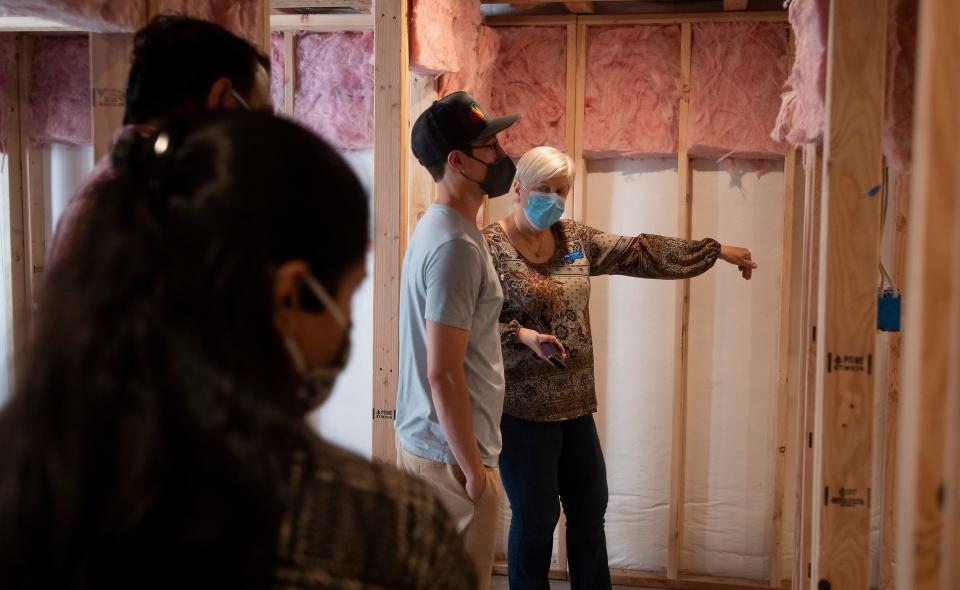 Real estate agent Leila Russell tours an unfinished basement with two interested parties during an open house in Fort Collins, Colo. on Saturday, May 8, 2021. 