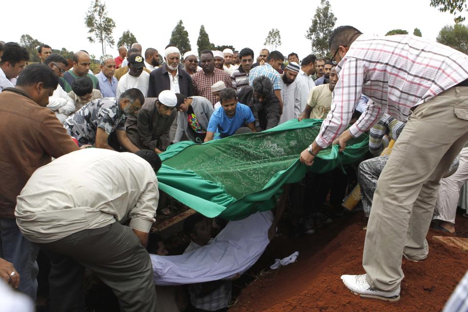 Relatives and Muslim faithful bury the slain body of Rehmad Mehbub, 18, who was killed in a crossfire between armed men and the police at the Westgate shopping mall, in Kenya's capital Nairobi September 22, 2013. Islamist militants were holed up with hostages on Sunday at a shopping mall in Nairobi, where at least 59 people have been killed in an attack by the al Shabaab group that opposes Kenya's participation in a peacekeeping mission in neighbouring Somalia. REUTERS/Thomas Mukoya (KENYA - Tags: CIVIL UNREST CRIME LAW OBITUARY) TEMPLATE OUT