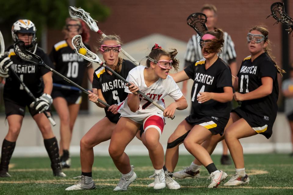 Park City’s Olivia Dalton moves away from Wasatch defenders in a 5A girls lacrosse semifinal game at Westminster College in Salt Lake City on Tuesday, May 23, 2023. | Spenser Heaps, Deseret News