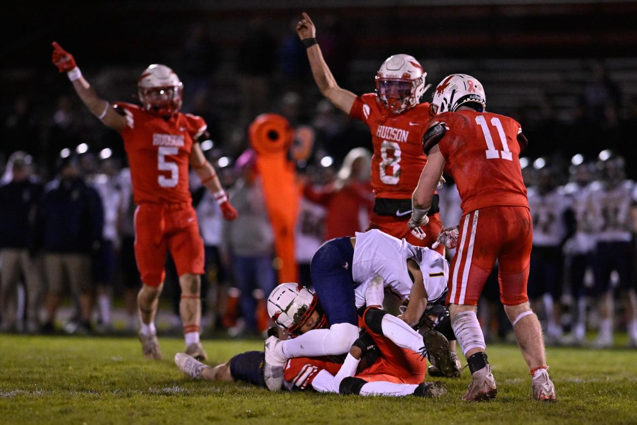 Hudson High junior Tyrese Meuse holds onto the ball after making an interception from Lynnfield senior Ethan Francis as teammates Owen Nanartowich, quarterback Jake Attaway and junior Garrett Giorgio look on during the Division 6, Elite 8 game versus Lynnfield at Morgan Bowl in Hudson, Friday, Nov. 10, 2023. Hudson defeated Lynnfield, 27-13.