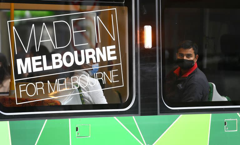 Un hombre con mascarilla en el tranvía en Melbourne