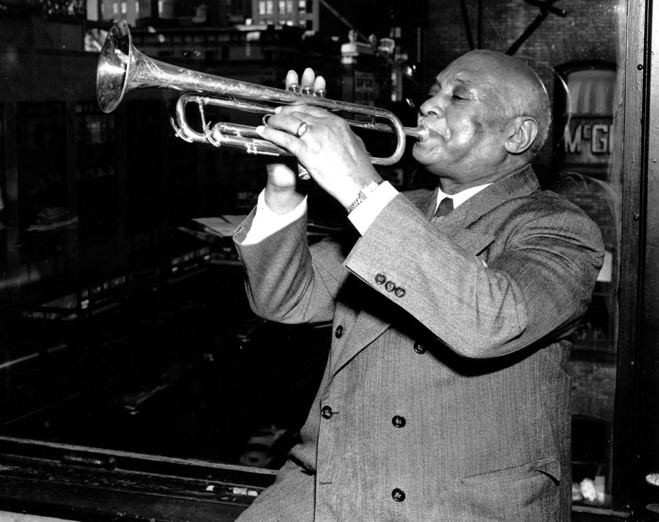 W.C. Handy, father of "the St. Louis Blues," sits in front of a window overlooking Times Square as he plays his trumpet in his New York publishing office on Nov. 11, 1949.