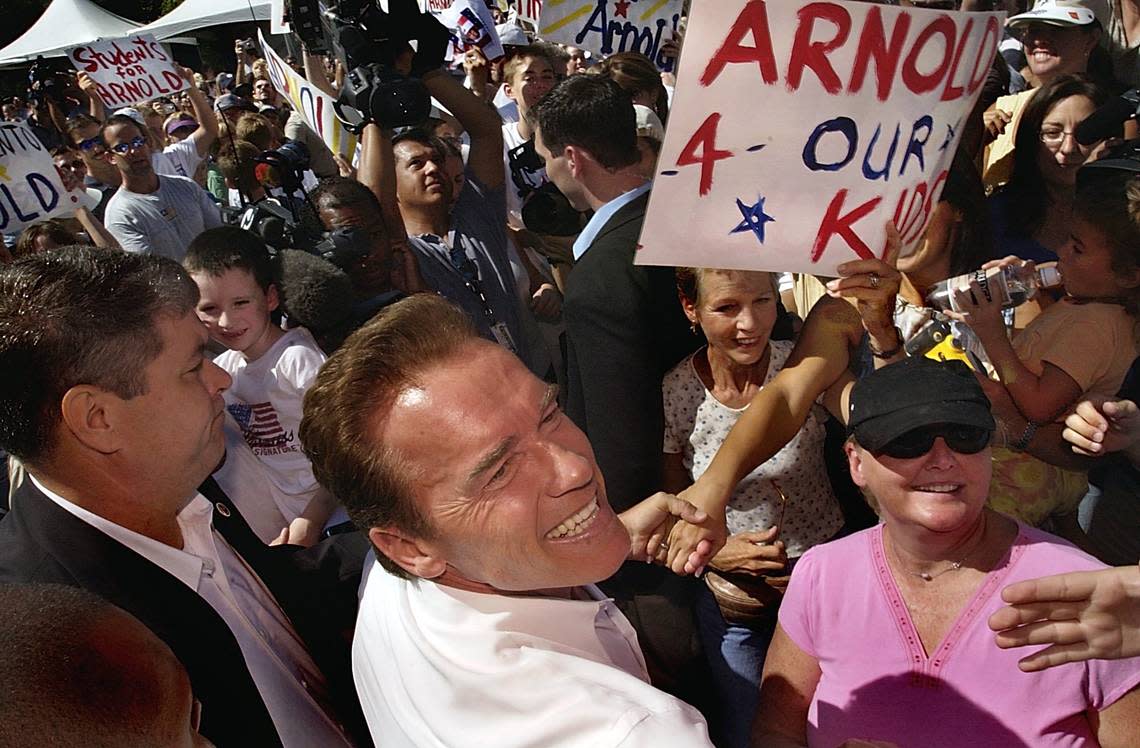 Actor and California gubernatorial candidate Arnold Schwarzenegger greets supporters on his way to a voter registration drive outside the main gate of the California State Fair on Sept. 1, 2003. MANNY CRISOSTOMO/Sacramento Bee file