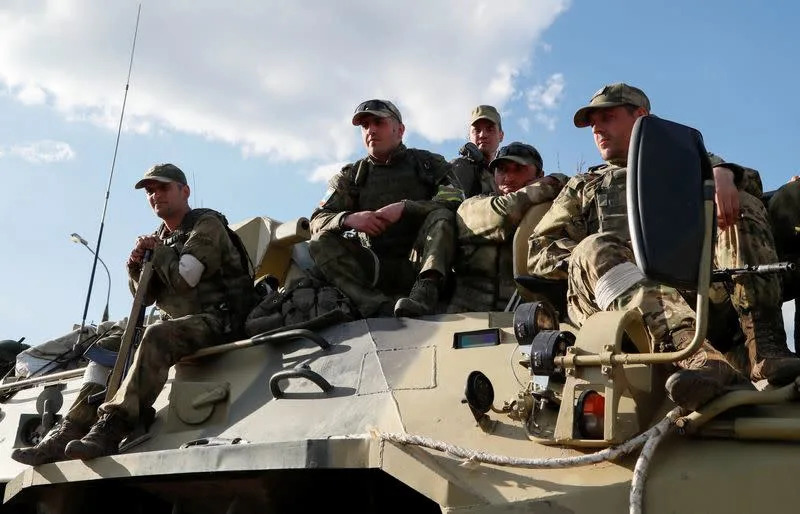 Service members of pro-Russian troops stand guard in Mariupol