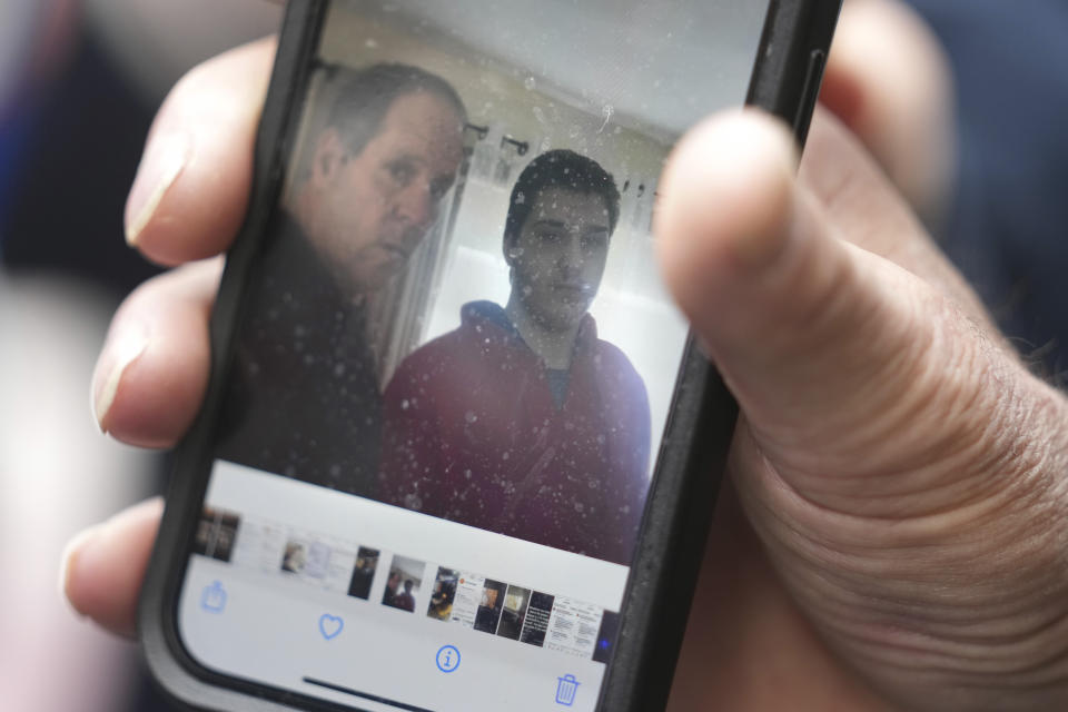 Paul Ventura, father of 18-year-old Mateo Ventura, both of Wakefield, Mass., displays a photograph on his cell phone that shows what he describes as a photo of himself and his son Mateo, right, while speaking with reporters outside federal court, Thursday, June 8, 2023, in Worcester, Mass. Mateo Ventura appeared in federal court Thursday on a charge of knowingly concealing the source of material support or resources to a foreign terrorist organization, the U.S. attorney's office in Boston said in a statement. (AP Photo/Steven Senne)