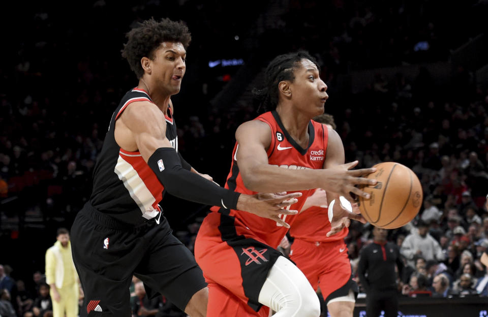 Portland Trail Blazers forward Matisse Thybulle, left, pokes the ball away from Houston Rockets guard TyTy Washington Jr., right, during the first half of an NBA basketball game in Portland, Ore., Sunday, Feb. 26, 2023. (AP Photo/Steve Dykes)