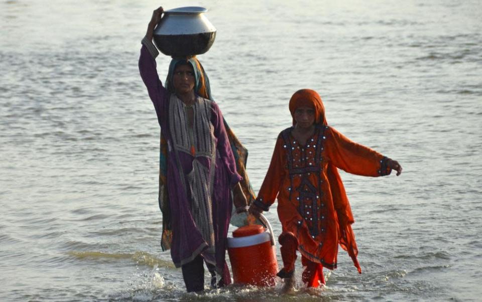 The women affected by the floods bring drinking water 