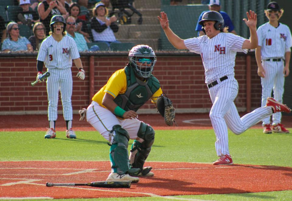 New Home's Brody Emert slides behind New Deal catcher Noah Rodriguez (center) for a run during their Region I-2A quarterfinal baseball series at Hays Field at Lubbock Christian University on Friday, May 20, 2022.