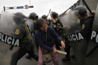 Supporters of former President Pedro Castillo confront riot police surrounding the police station where Castillo arrived earlier, in Lima, Peru, Wednesday, Dec. 7, 2022. Peru's Congress removed Castillo from office Wednesday, voting to replace him with the vice president, shortly after Castillo decreed the dissolution of the legislature ahead of a scheduled vote to oust him. (AP Photo/Martin Mejia)