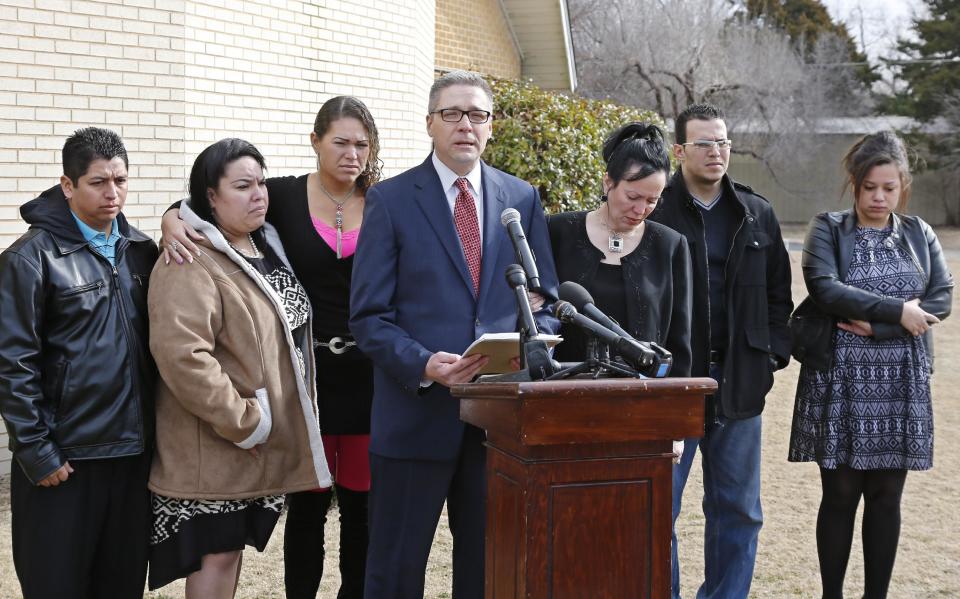 Members of the Rodriguez family are pictured with attorney Michael Brooks-Jimenez, fourth from left, during a news conference in Oklahoma City, Tuesday, Feb. 25, 2014. From left are Juan Jantes, Yashira Jantes, Francheska Medina, Michael Brooks-Jimenez, Nair Rodriguez, Ryan Medina and Luinahi Rodriguez. At the news conference, the family of Luis Rodriguez, a man who died after a struggle with police outside an Oklahoma movie theater, released a cellphone video of the incident that shows the man on his stomach on the ground with five officers restraining him, including one officer holding his head down. (AP Photo/Sue Ogrocki)