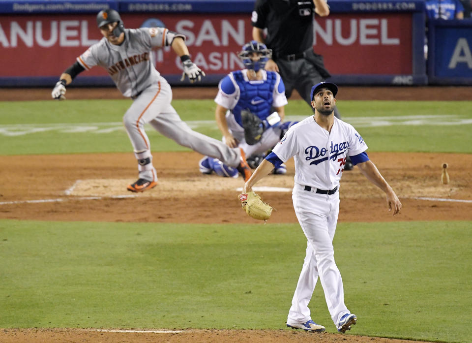 San Francisco Giants' Chase d'Arnaud, left, hits a single as Los Angeles Dodgers relief pitcher Scott Alexander, right, watches along with catcher Austin Barnes during the ninth inning of a baseball game, Monday, Aug. 13, 2018, in Los Angeles. (AP Photo/Mark J. Terrill)