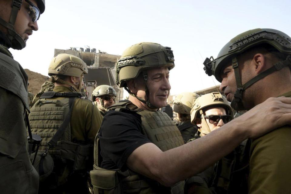 Israel's Prime Minister Benjamin Netanyahu, centre, greets soldiers as he visits the Gaza Strip, where he received security briefings with commanders and soldiers and visited one of the tunnels that has been revealed, on Sunday Nov. 26, 2023. (Avi Ohayon/GPO/Handout via AP)