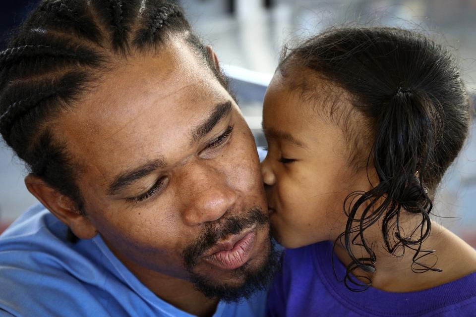 Pharaoh Haywood receives a kiss from his daughter during a "Get On the Bus" visiting day to Folsom State Prison