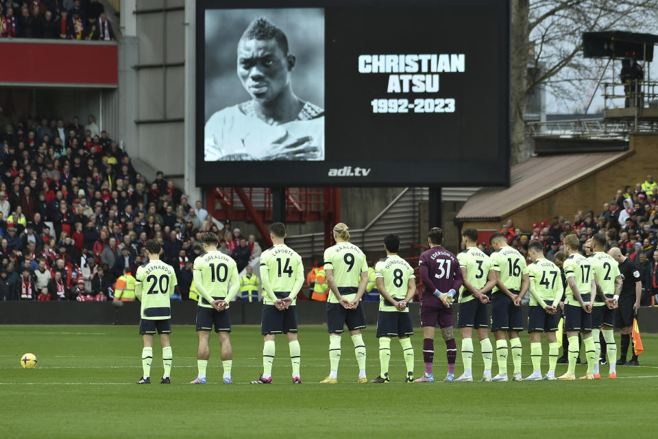 Players pay a minute of silence as tribute to Christian Atsu who died in the Turkey earthquake ahead the English Premier League soccer match between Nottingham Forest and Manchester City at City ground in Nottingham, England, Saturday, Feb. 18, 2023. (AP Photo/Rui Vieira)