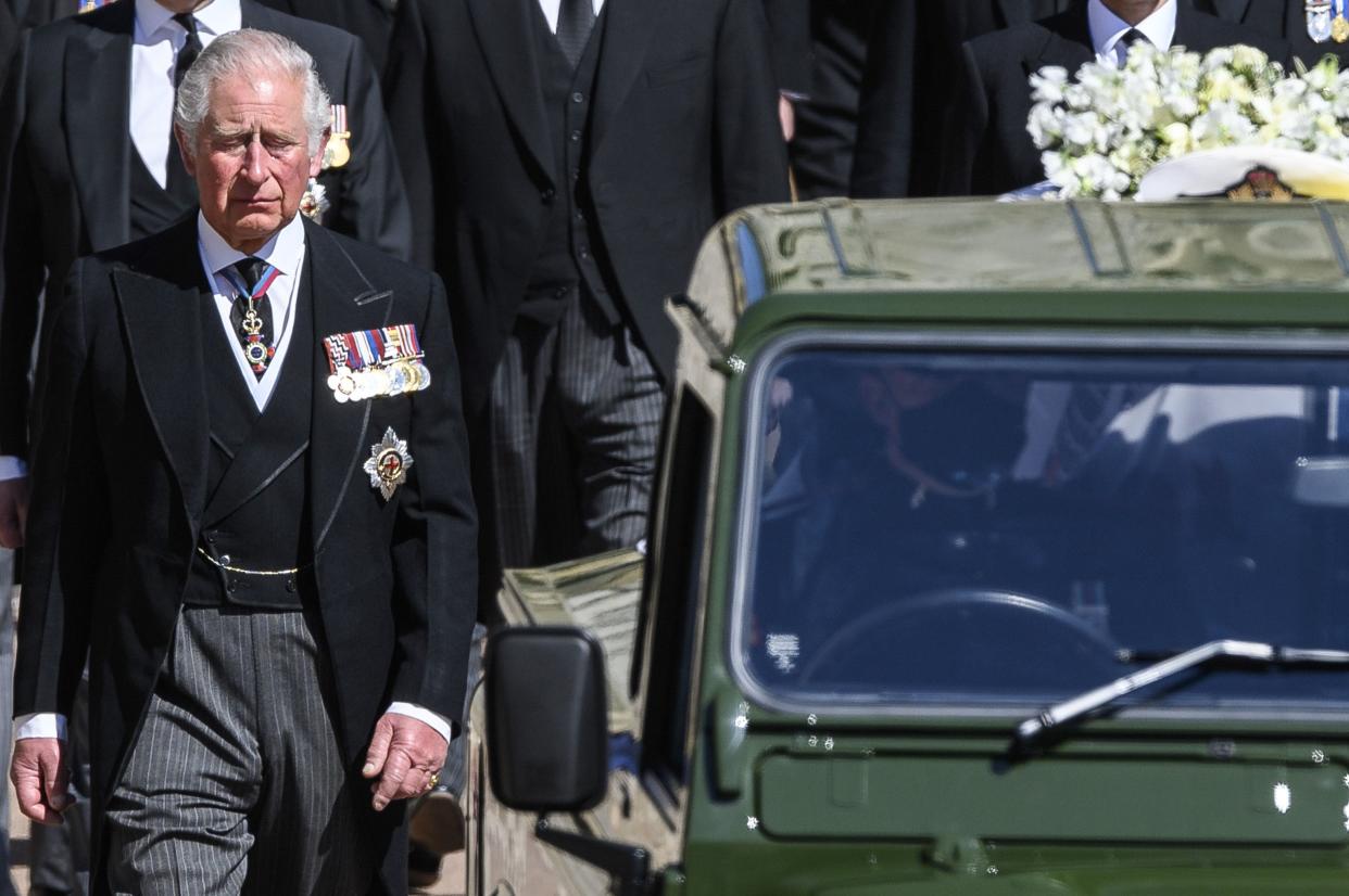 Britain's Prince Charles follows the coffin as it makes it's way past the Round Tower during the funeral of Britain's Prince Philip inside Windsor Castle in Windsor, England Saturday April 17, 2021.