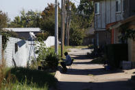 Retiree Patrick Vancooper tends to his garden on a strip of land between an alley and a fence on Monday, Oct. 25, 2021, in Dalworthington Gardens, Texas, a small municipality that's tucked within the city of Arlington. Vancooper's home is near a compressor station for natural gas. Fumes can often be smelled in the neighborhood, depending on which way the wind blows, but he says his neighbors rarely question what it is. (AP Photo/Martha Irvine)