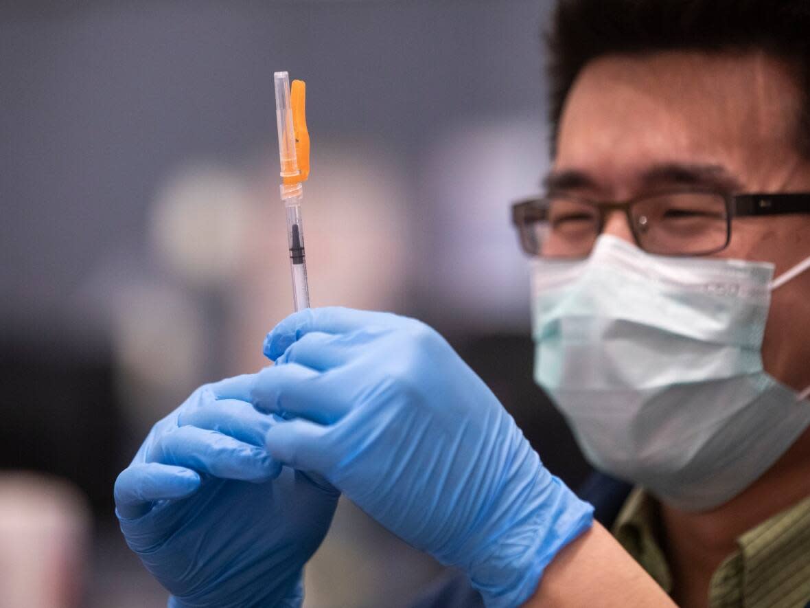 A coronavirus vaccine is prepared at a clinic in Vancouver earlier this year. The bivalent booster shots are now available to adults across provinces in Canada.  (Ben Nelms/CBC - image credit)