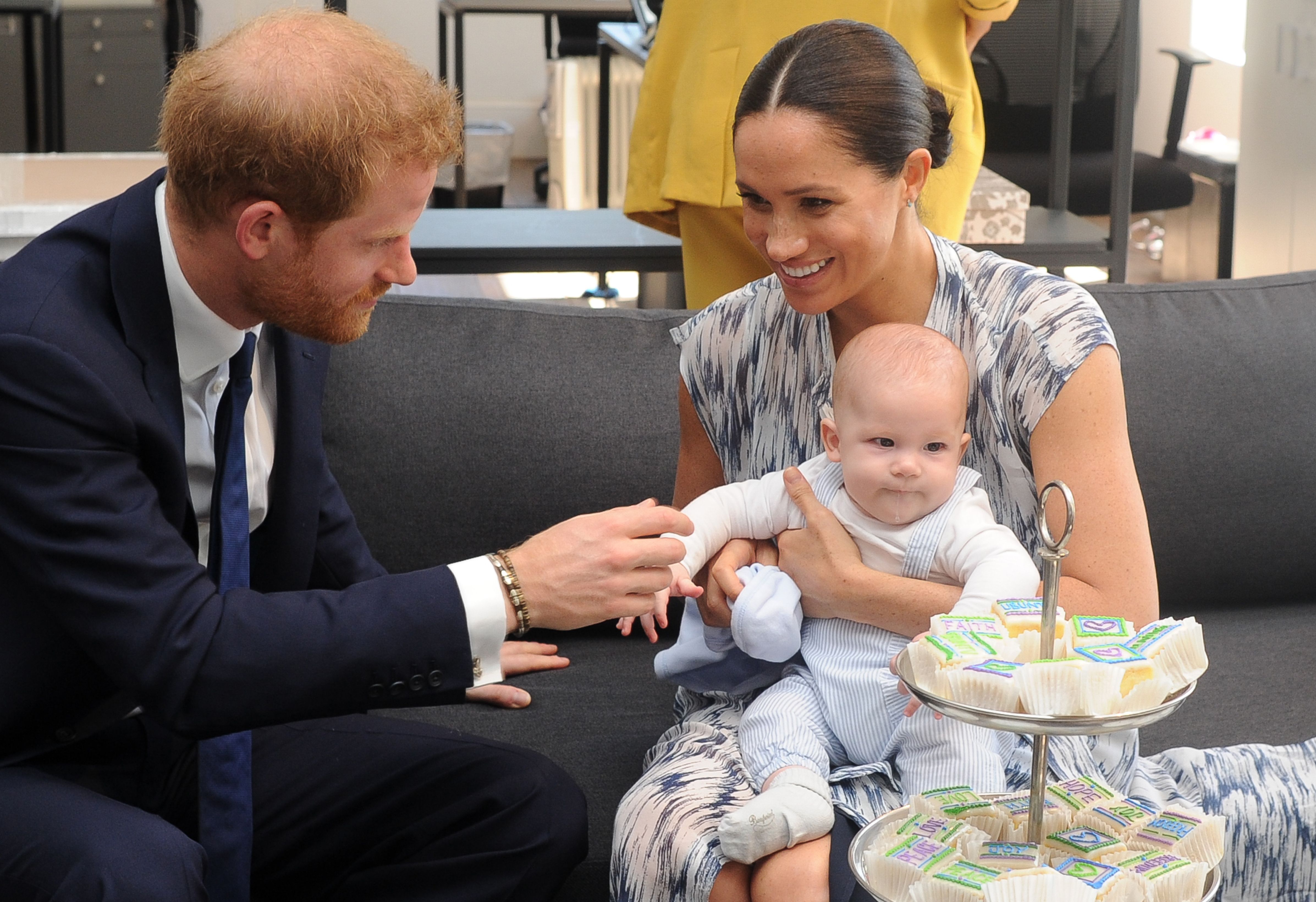 Britain's Duke and Duchess of Sussex, Prince Harry and his wife Meghan hold their baby son Archie as they meet with Archbishop Desmond Tutu (unseen) at the Tutu Legacy Foundation  in Cape Town on September 25, 2019. - The British royal couple are on a 10-day tour of southern Africa -- their first official visit as a family since their son Archie was born in May. (Photo by HENK KRUGER / POOL / AFP)        (Photo credit should read HENK KRUGER/AFP/Getty Images)