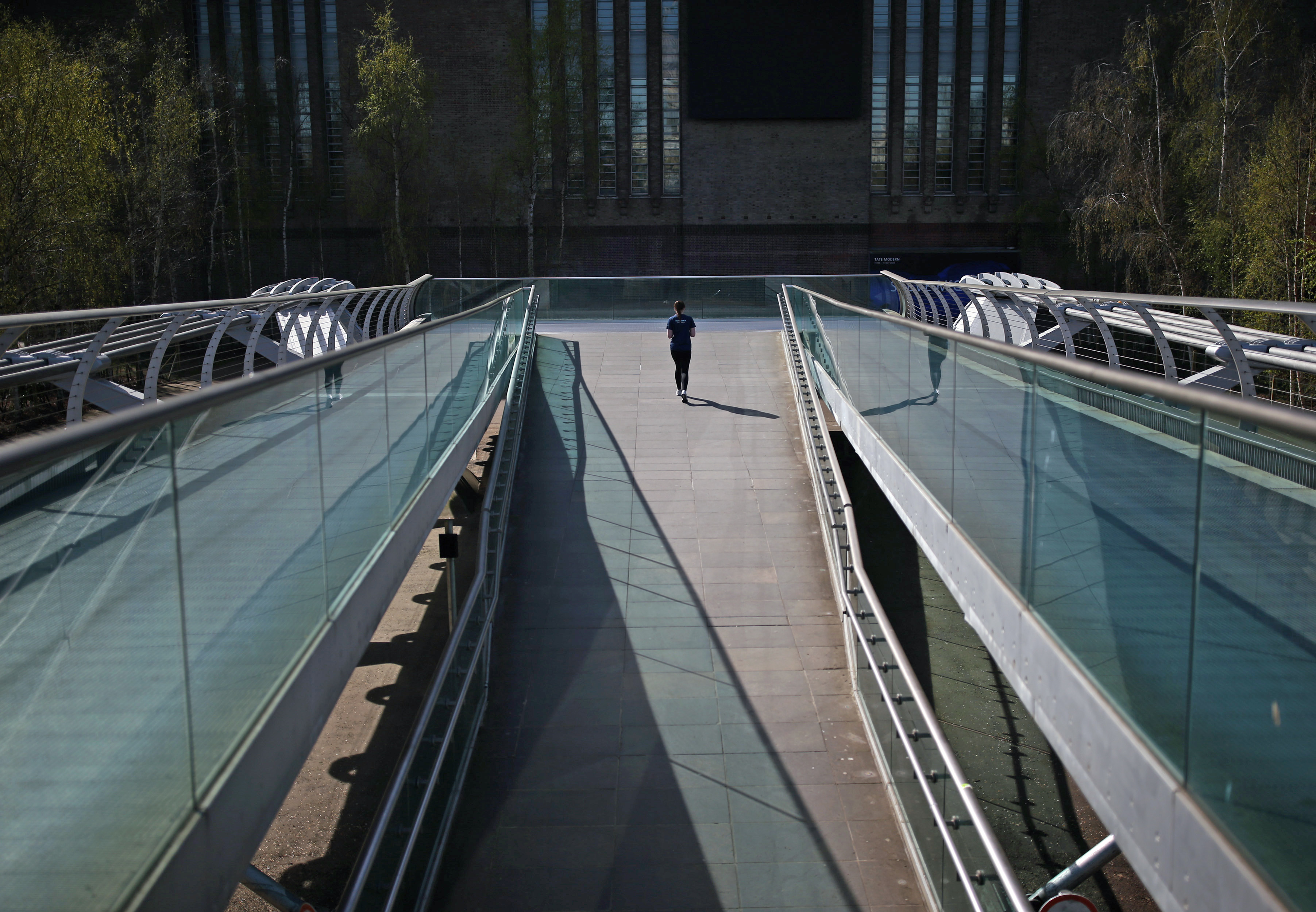 A woman jogging on the Millennium Bridge in London, as the UK continues in lockdown to help curb the spread of the coronavirus.