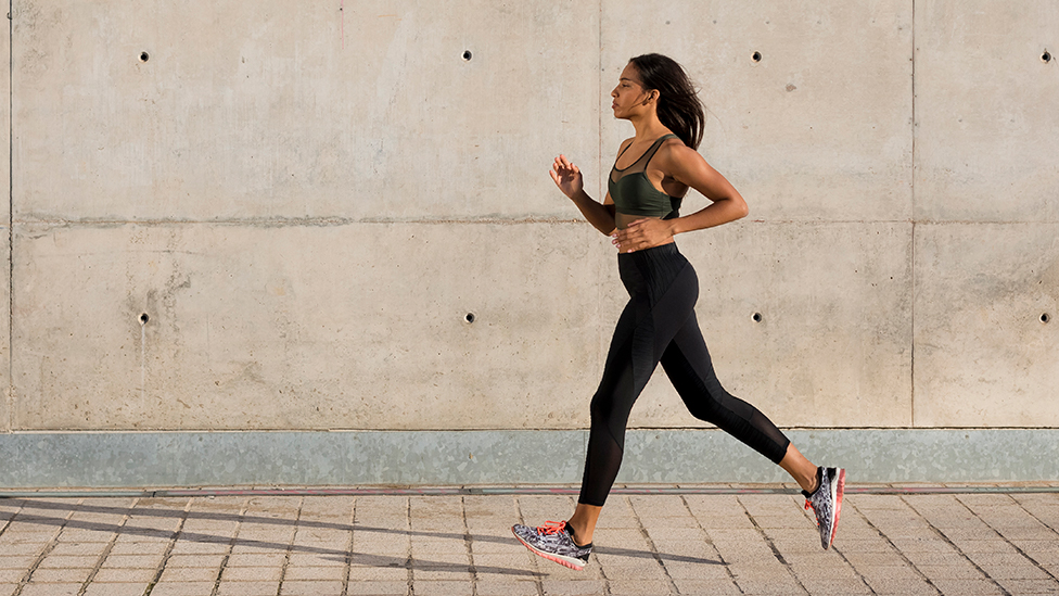 Female runner running at summer park trail . Healthy fitness woman