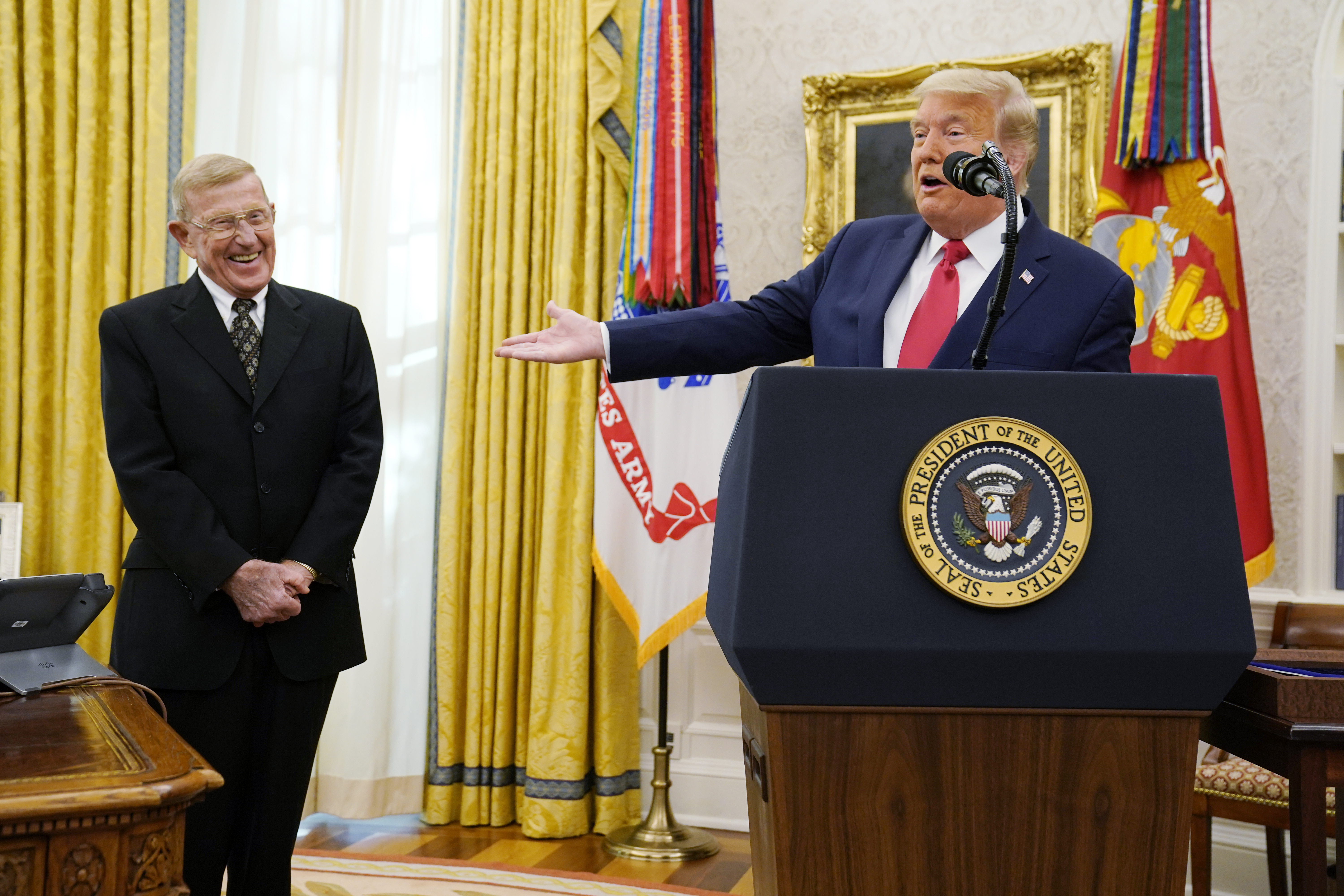 President Donald Trump speaks before awarding the medal of Freedom, the highest civilian honor, to former college football coach Lou Holtz in the Oval Office at the White House, Thursday, Dec. 3, 2020, in Washington. Holtz had a storied 34-year coaching career that included winning the 1988 national title at the University of Notre Dame. (AP Photo/Evan Vucci)