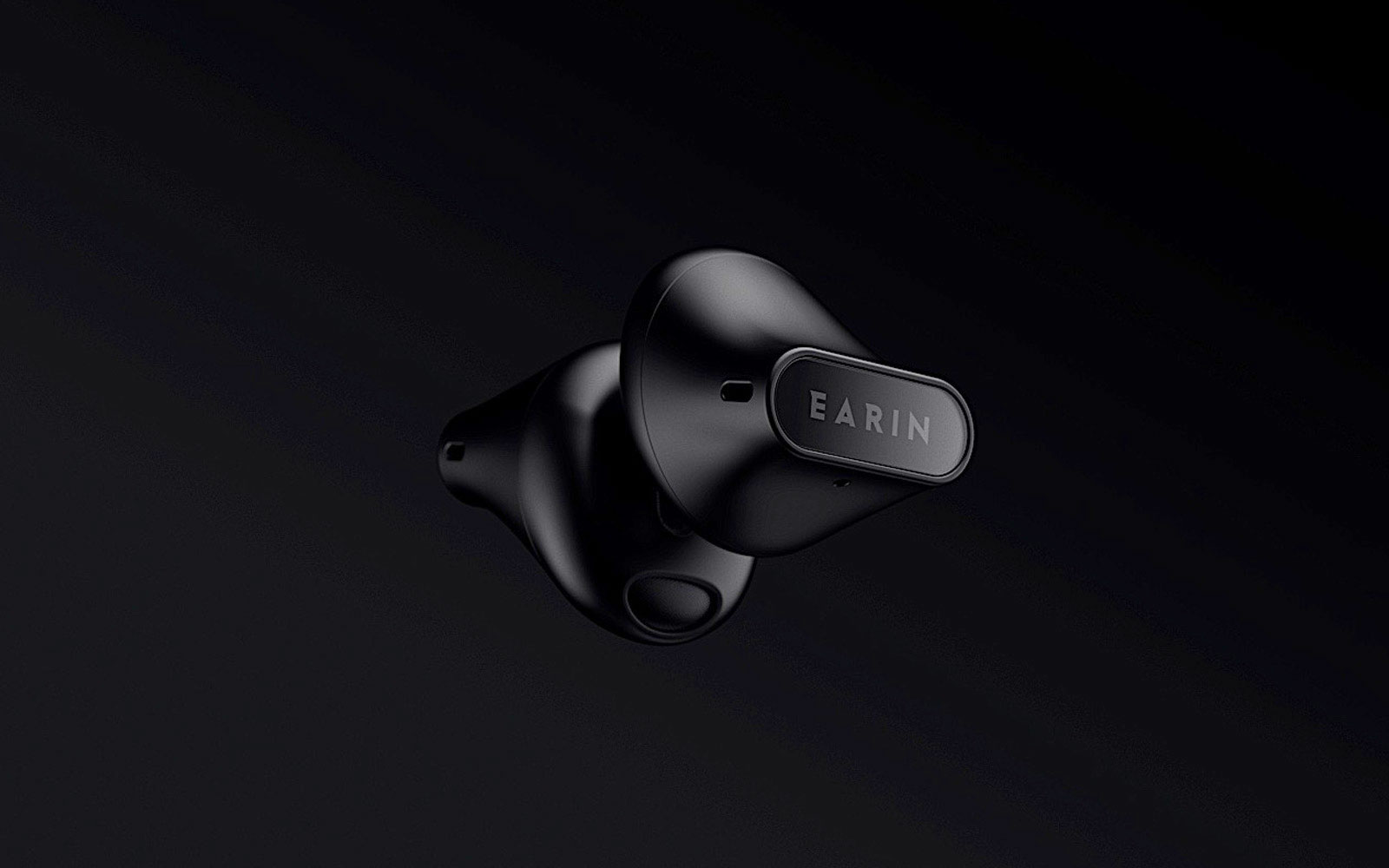 Earin A-3 earbuds in black on a black background.