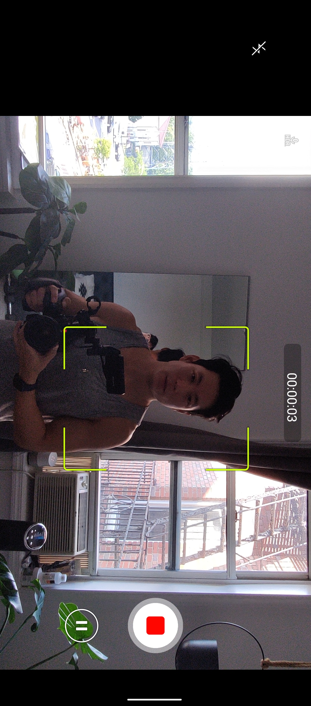 A screenshot of the camera app in the Smartphone for Snapdragon Insiders, demonstrating an Auto Tracking video recording mode. There is a yellow square surrounding a man and Stop and Pause buttons on the right.. 