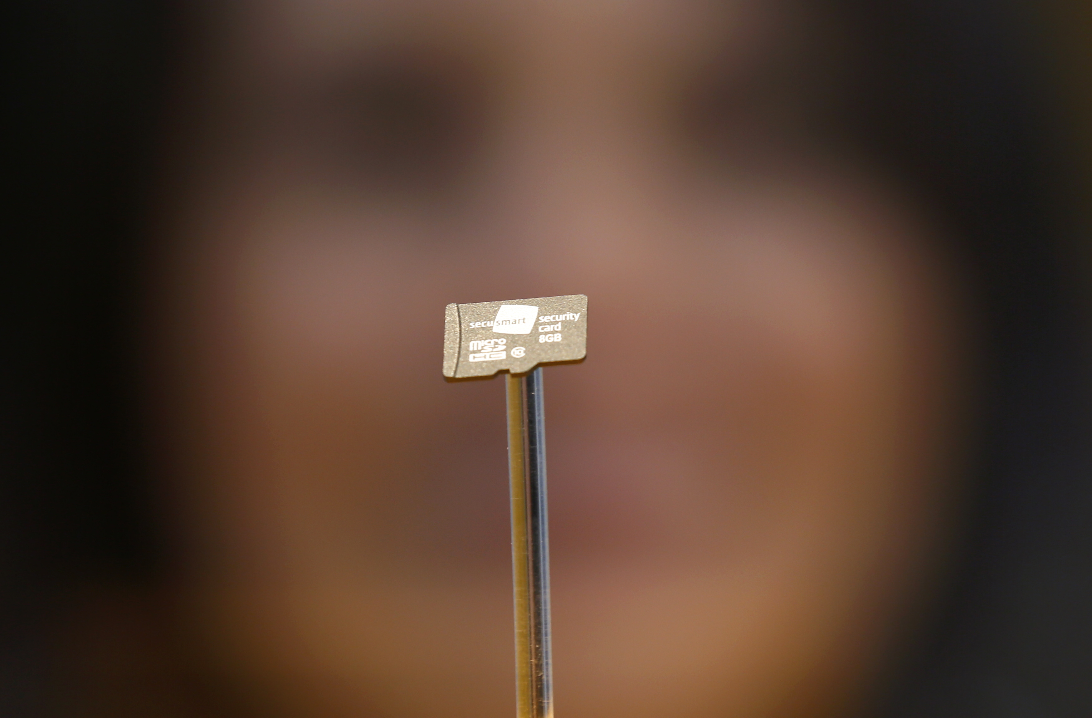 A woman looks at a data chip containing encryption codes for mobile and landline phones at the booth of Secusmart during the CeBIT trade fair in Hanover March 8, 2014. The German company Secusmart is known for supplying German Chancellor Angela Merkel with a secure mobile phone. The world's biggest computer and software fair will be open to the public from March 10 to 14.  REUTERS/Wolfgang Rattay (GERMANY - Tags: BUSINESS TELECOMS SCIENCE TECHNOLOGY)