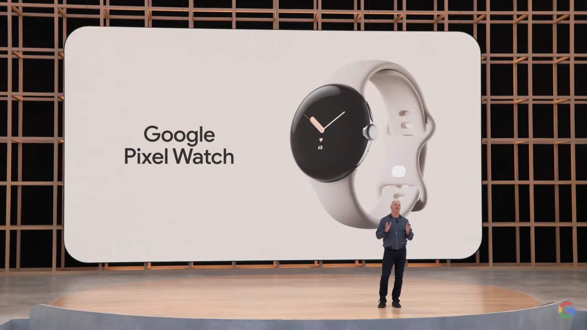 Google hardware chief Rick Osterloh standing on stage in front of a picture of the Pixel Watch.